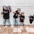 sibling matching outfits holding a boom box from the 90s with backward caps announcing their new baby sibling in football style matching shirts the original the remix sets